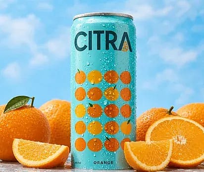 Orange soda can beside fresh oranges