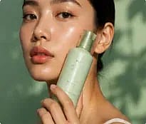 Model holding a green skincare bottle