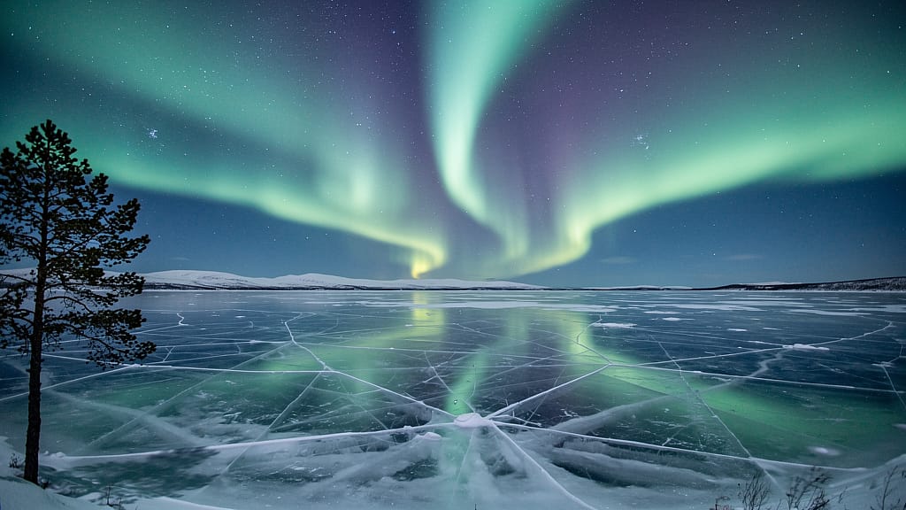 Aurora Borealis Reflection — Aurora borealis with emerald and violet ribbons reflected in a frozen Norwegian lake, sing