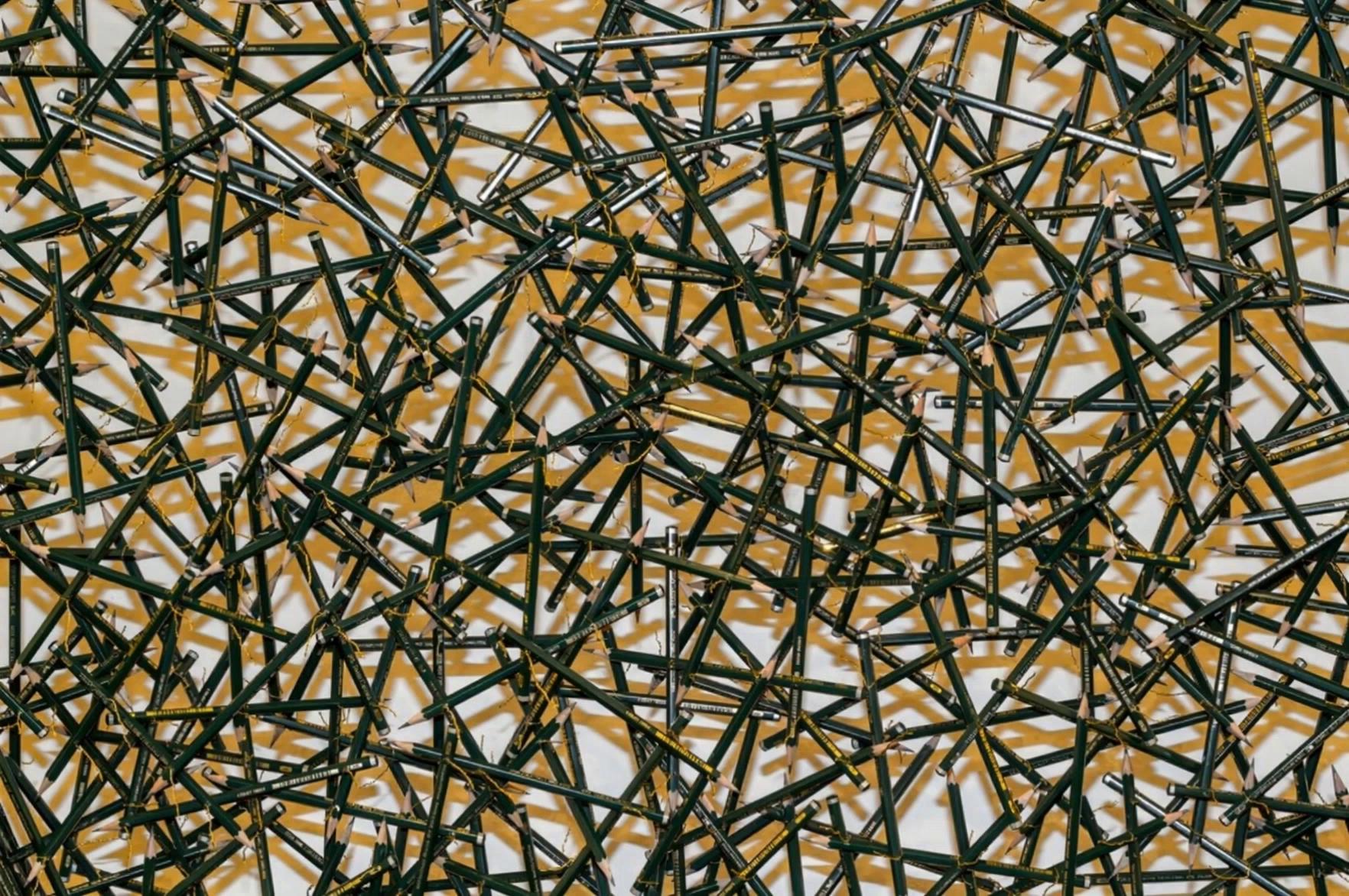 Prompt: Use the reference image exactly as it is. Preserve the white background, lighting, colors and camera position.The interconnected pencil mesh behaves as one living collective organism inspired by the collective movement of a large school of fish. No fish appear at any time.A gentle impulse begins in one small region of the mesh. Nearby pencils immediately respond, creating smooth flowing curves that travel naturally through the connected network. The movement spreads continuously from one local group to the next, forming elegant spirals, broad circular paths and graceful sweeping arcs.Several rotating movement centers emerge simultaneously, slowly drifting across the structure. These rotating centers merge, separate and dissolve while continuously generating new flowing patterns. The movement is smooth, uninterrupted and hypnotic, with no abrupt direction changes.The entire mesh appears almost weightless, continuously gliding through invisible forces. Every motion flows seamlessly into the next, creating an endless sequence of expanding spirals, rotating formations and synchronized circular movement. The movement never stops. Every curve naturally evolves into the next one without interruption. There are no sudden starts or stops, only continuous flowing motion.The overall structure always remains recognizable. Every individual pencil remains perfectly rigid. Only the thin wire connections flex naturally, transmitting motion throughout the network.No water.No ocean.No underwater scene.No water surface.No ripples.No waves on the background.No bubbles.No fish.No animals.No additional objects.No morphing.No camera movement.