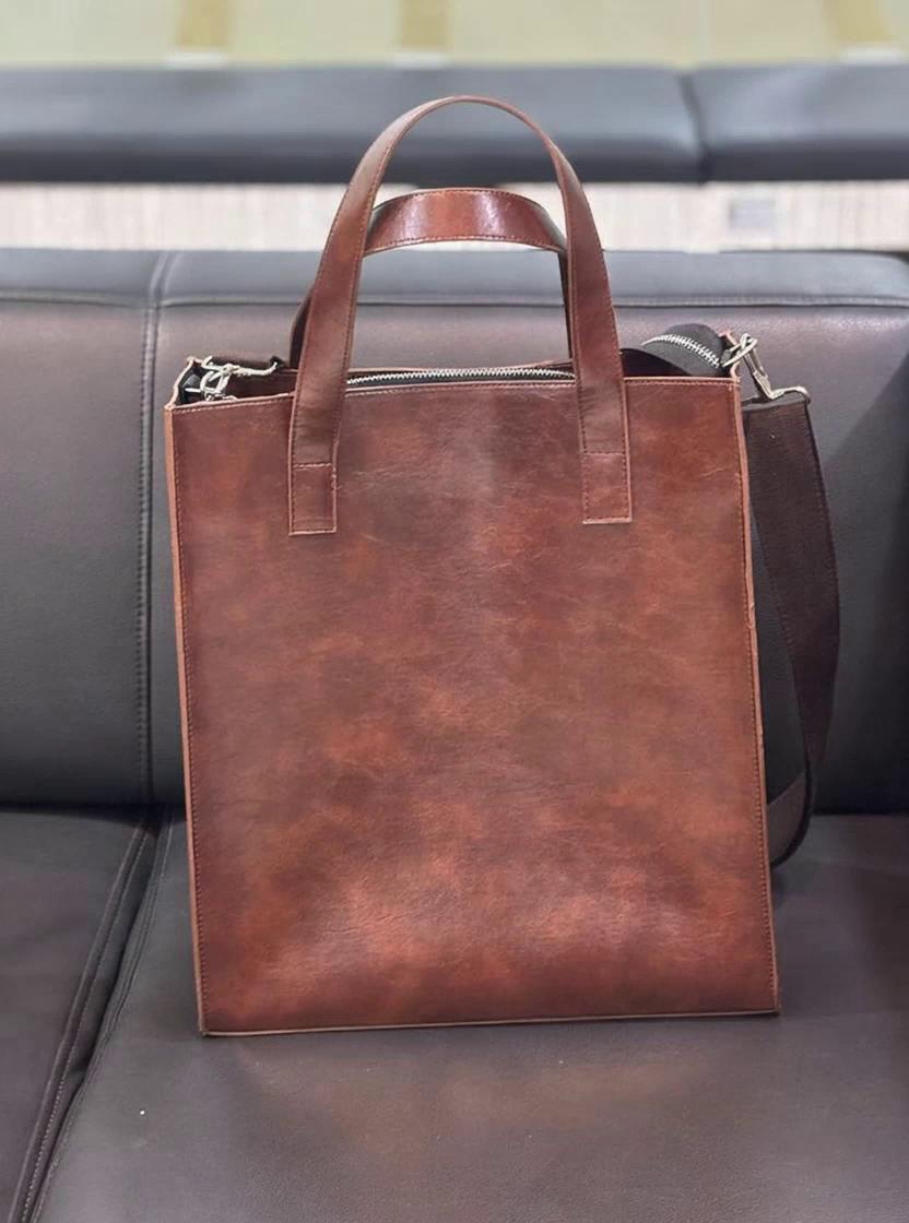 Prompt: Visual Idea:
	•	Model perempuan berdiri tegak, memegang beg PU Leather di tangan kiri (elegant style).
	•	Model lelaki di sebelah kanan, sandang beg di bahu (business casual look).
	•	Kamera zoom out perlahan-lahan dari beg ke badan atas model (half body shot).
	•	Background plain minimalist (cream or beige) supaya beg lebih menyerlah.