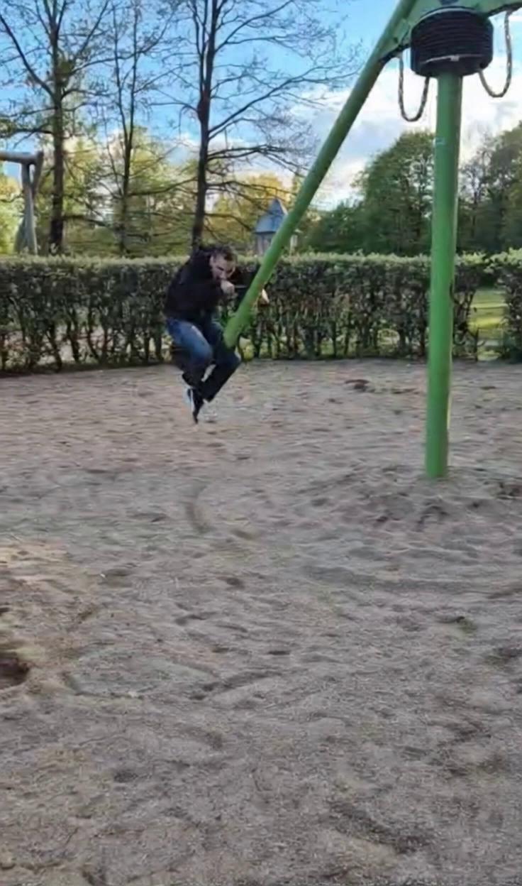 Prompt: He rides the spinning swing and it goes very fast and the camera will be pointing at him