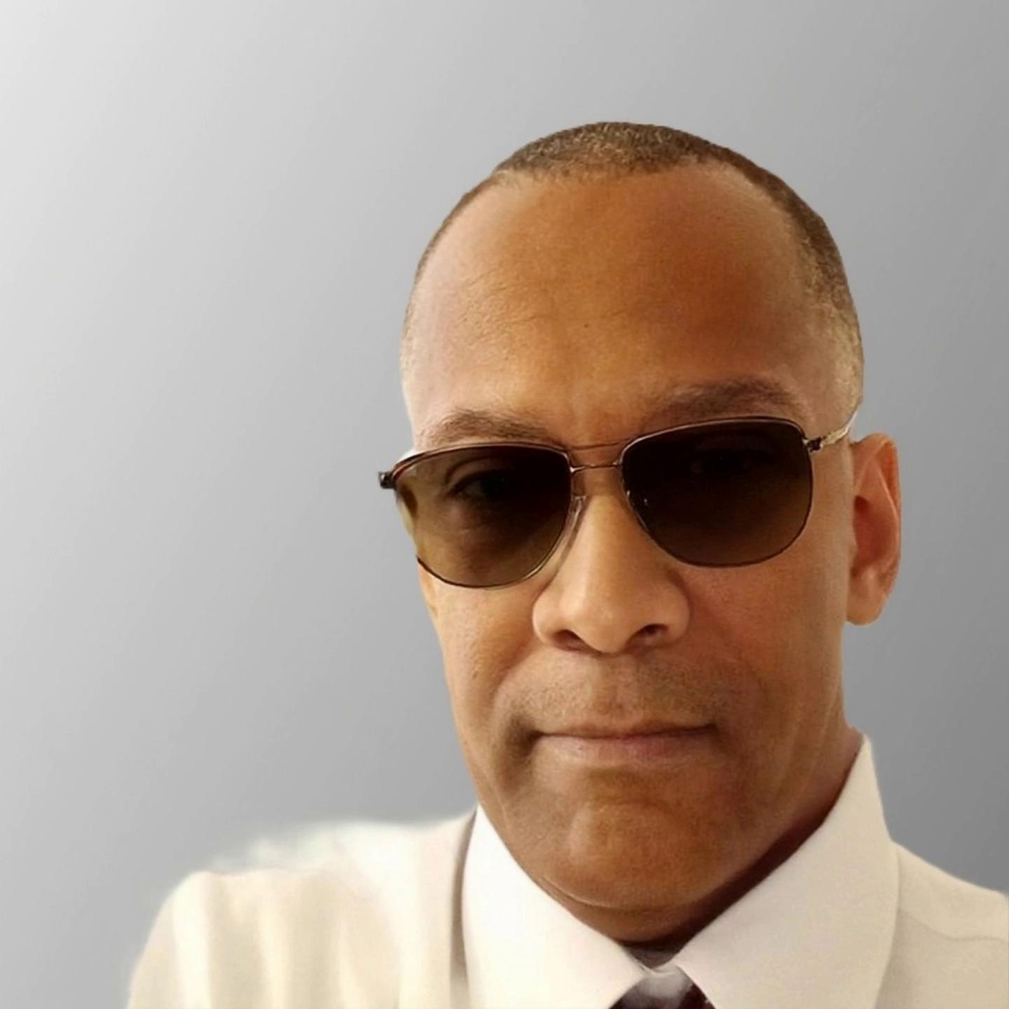 Prompt: Create a video of this man wearing a suit walking around a table of executives giving a speech.