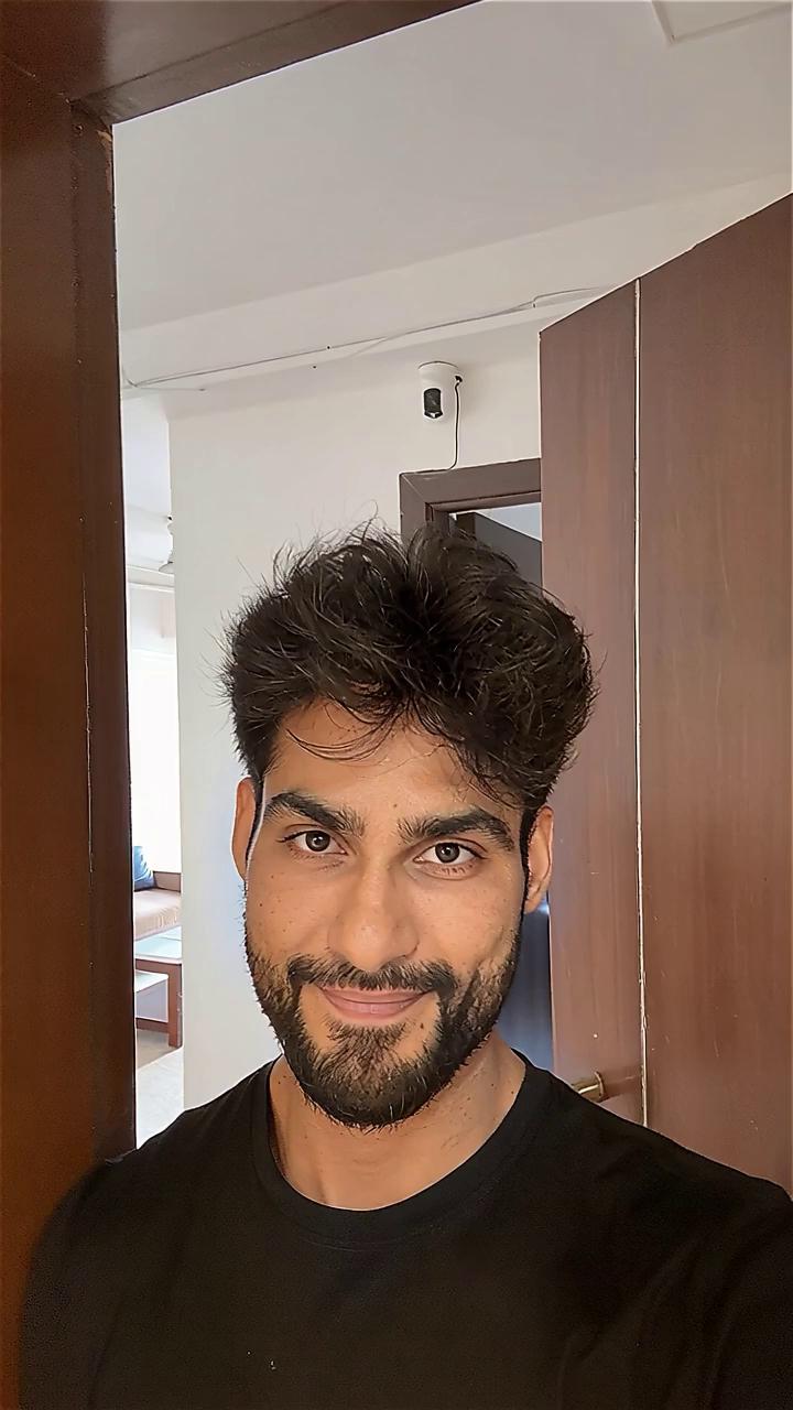 Prompt: cinematic portrait of a young Indian man in his late 20s slightly unshaven, deep thoughtful eyes, medium build, natural warm brown skin tone, wearing a simple layered outfit (white shirt, navy jacket), sitting near a window with soft golden light falling on his face, expression calm but emotional, eyes distant as if lost in thought, background softly blurred, high detail, cinematic color grading, subtle bokeh, realistic skin texture, film grain, emotional realism, moody lighting, shot on 35mm lens, aesthetic tone like “Before Sunrise” meets “In the Mood for Love”