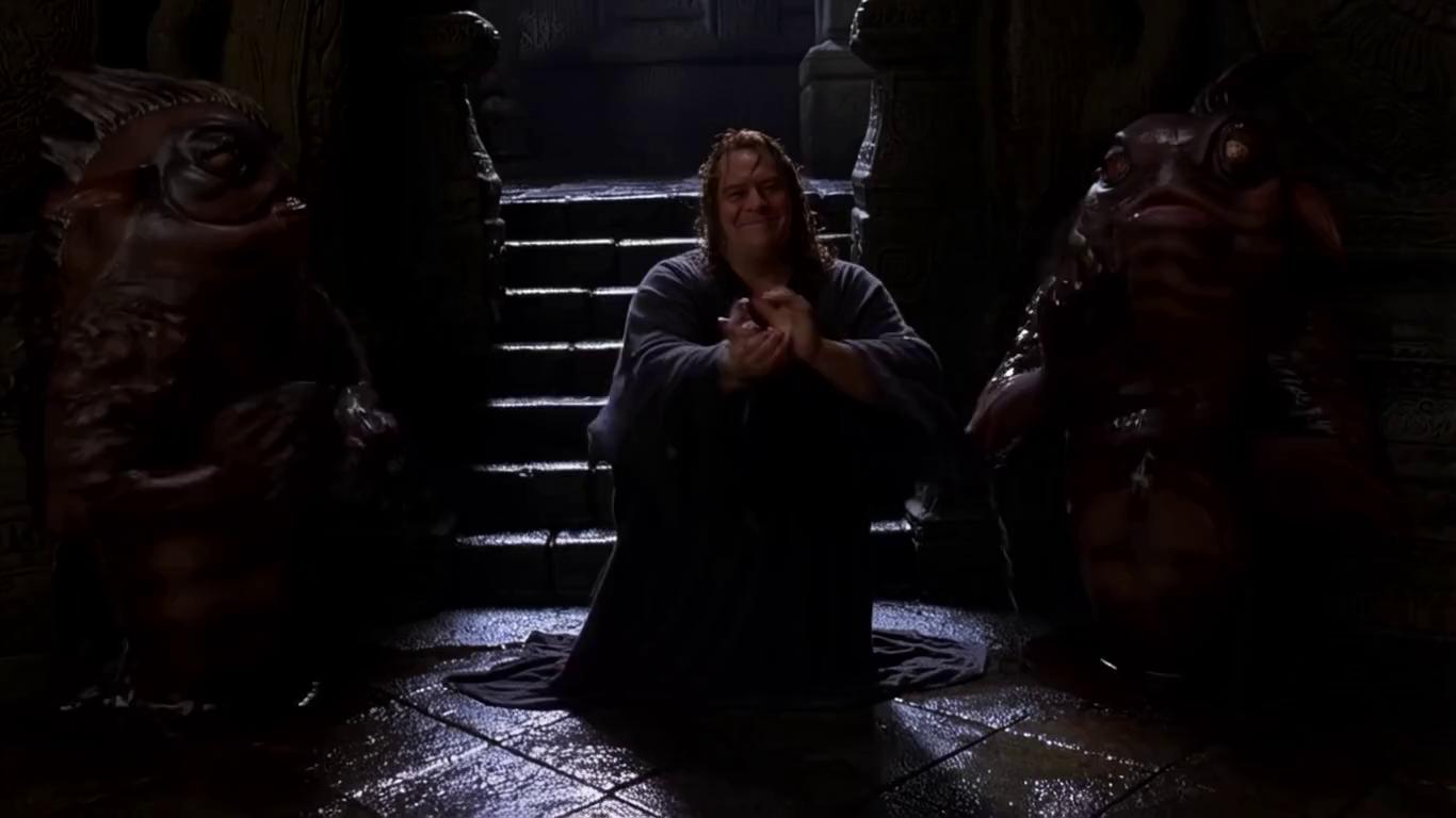 Prompt: ((Live-action, cinematic, hyperrealistic, film-like, dark wet temple, Tarantino absurd humor))  
((Handheld medium shot, shaky cam)) Laymos laughs dryly while teaching two kuo-toa (wet fish-men, dripping gills) to clap in rhythm. They mimic clumsily. Camera zooms on Laymos’ smirk, water dripping on stone floor. Mood grotesque and surreal, like awkward friends in a Tarantino film.
