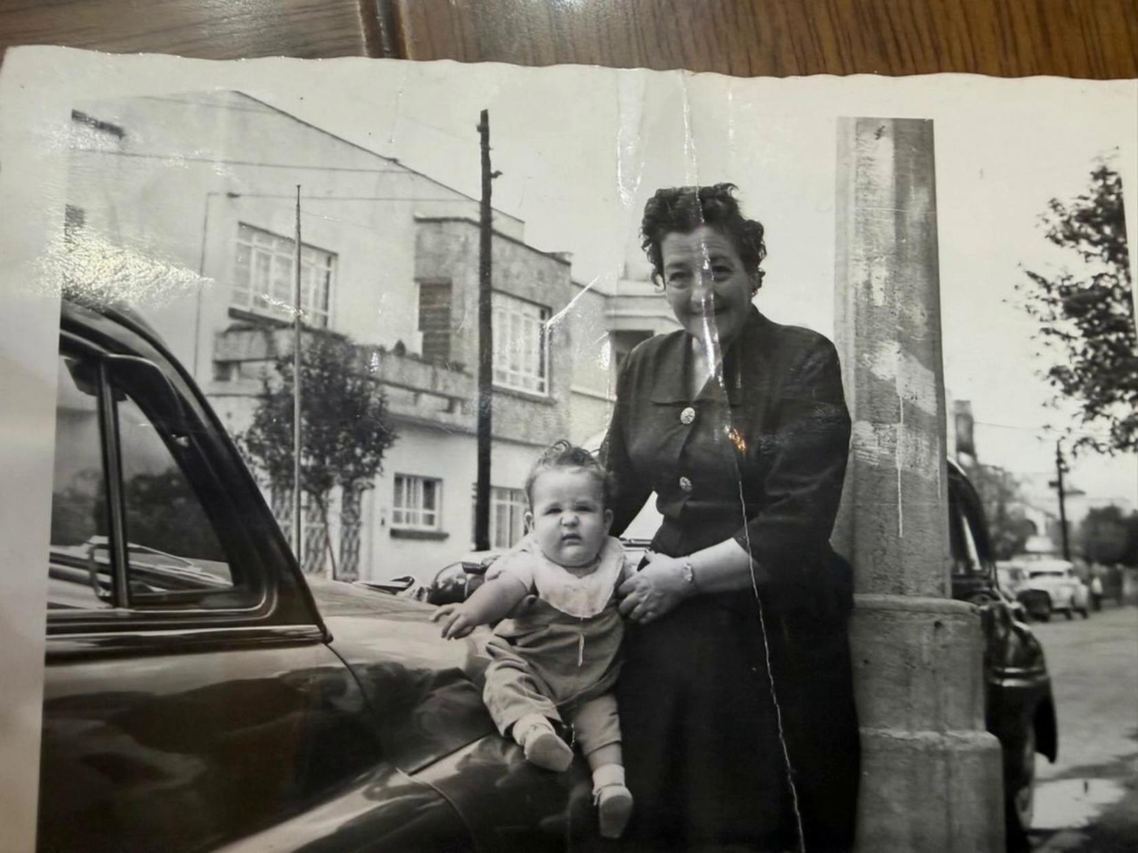 Prompt: escena de mi abuela con mi hermano quiero que lo cargue le de un beso, muy cariñoso, duracion 10 segs, t todos saludando a la camara