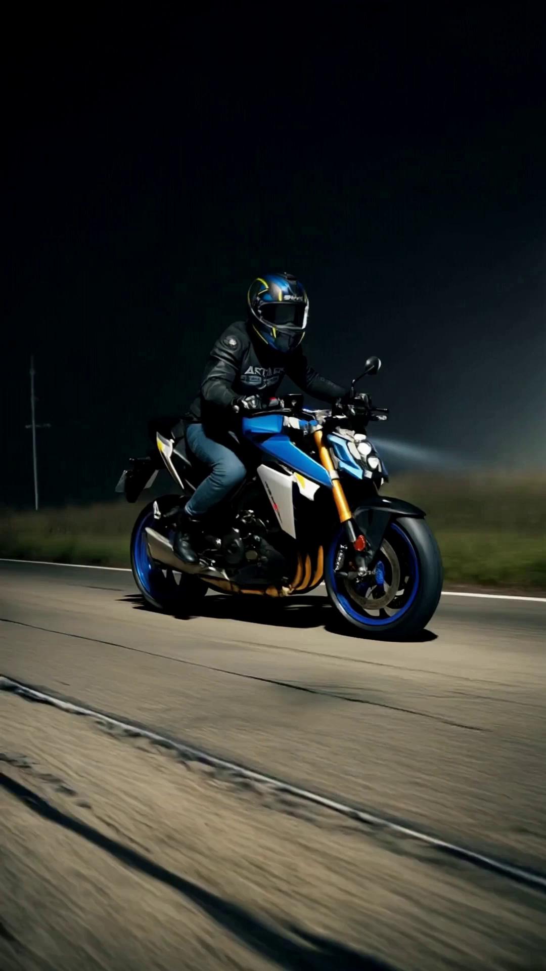 Prompt: Rider@image-1767028287806-3  riding the motorbike similar to  @image-1767028272806-2 and @image-1767028826664-4  on a grungy asphalt lowering speed to 60km per hour then performing a wheelie for 6 seconds at night in a dark environment and a dark background where the focus is only on the rider. Fast Action, Cinematic film look and aesthetics, Depth of field, dramatic, cinematic lighting