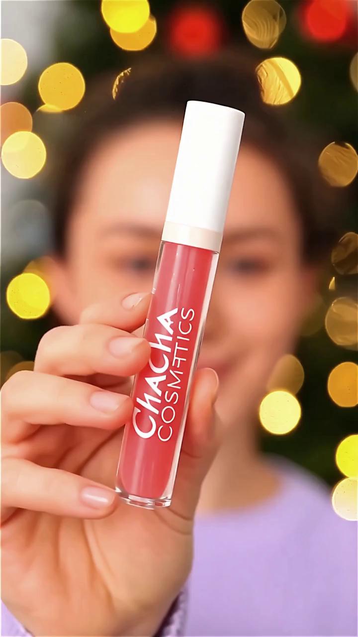 Prompt: A vertical 9:16 beauty commercial video for a young and playful cosmetics brand called Chacha Cosmetics.

Scene opens with a close-up of a lip gloss product held in a female hand. The product is the main focus in the first frame. Soft festive Christmas lights in the background, bokeh effect, warm cozy atmosphere.

The model is a naturally beautiful young woman, girl-next-door vibe, minimal makeup, healthy glowing skin, natural freckles, soft smile.

She wears a soft lilac knit sweater that matches the brand color palette.

She gently applies the lip gloss to her lips using the applicator. The gloss looks shiny, juicy, and hydrating.

Brand color accents: lilac and soft orange tones subtly reflected in lighting and background details.

Mood: confident, fun, authentic, fresh, not overly posed, not influencer-perfect.

Lighting is soft, warm, and flattering, cinematic but realistic.

Text overlay appears smoothly:
“New Year, New Glow ✨”

End frame shows the product clearly next to the model’s smiling face.

Style: modern beauty ad, Instagram Reels style, natural movement, clean aesthetic, youthful energy.