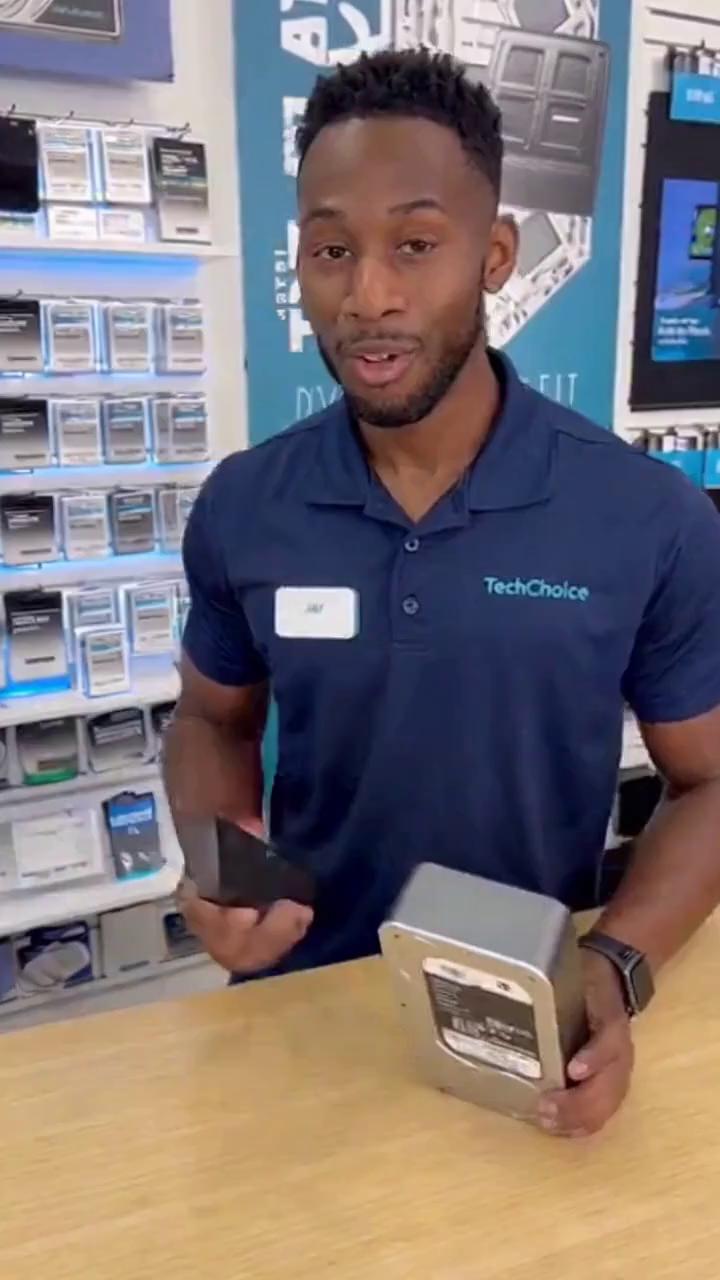 Prompt: a real life commercial of dark-skinned black man, working at electronic shop , selling hard drives. states in camera "want to get rid of those monthly subscriptions, own your own media by choosing us today!!"