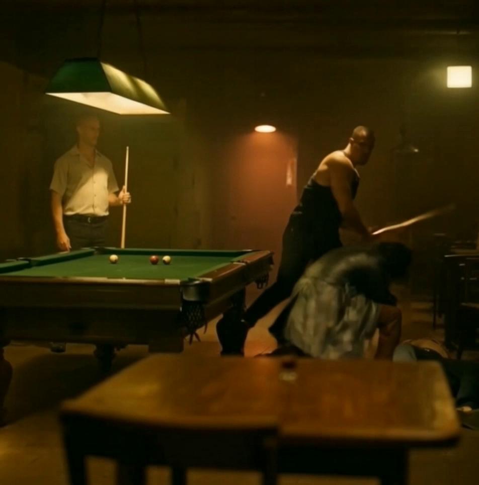 Prompt: Subject in foreground wearing  leather trench coat rises from his ducked position after avoiding the swinging pool cue, he hits the subject in background with a hard uppercut punch in the chin, the Impact lifts subject in  background off his feet and he lands on his back on the bar room floor, 