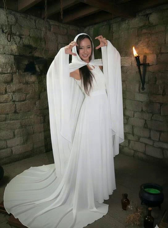 Prompt: A beautiful asian witch bride screams "i'm melting" and her head and body completely sinks & melts into her cloak and gown, and her cloak and gown slowly fall onto the floor as an empty cloak and gown deflating on the floor.