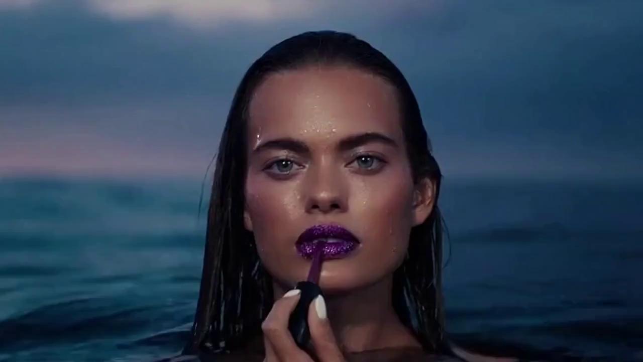 Prompt: Create a cinematic video. It is a concept for a fictional makeup product line called “Passion by Paysleigh.” Spelled exactly like that. The scenes should all be realistic and cinematic. The first scene should be a siren slowly rising from the water looking directly at the camera and applying deep purple glittery lipstick. The second scene should be the packaging concept for the product line, along all the products in the makeup kit. The third scene should be a white blonde human like fairy walking into Sephora to look at the makeup line. The fourth scene should be a fairy on a unicorn applying the eye shadow along with closeups. The fifth scene should do a zoom in to the packaging for the makeup product line Passion by Paysleigh. The sixth scene should be a siren swimming in deep purple glittery and glossy liquid. The last scene should be fairies spelling out “Passion by Paysleigh” 