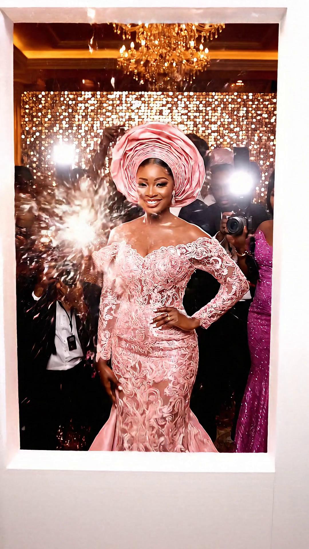 Prompt: Prompt:
A beautiful Nigerian woman wearing a blush pink, off-shoulder, beaded lace gown with a matching gele arrives at a lively owambe party. She poses naturally at the photo booth while paparazzi snap photos from different angles. Camera flashes reflect softly on her glittering dress as people chat and music plays in the background, creating a joyful, authentic party atmosphere.