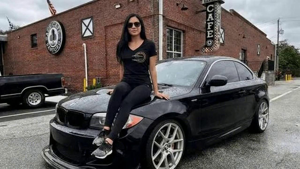 Prompt: a woman sitting on a black sportscar wearing sunglasses "Welcome to one love car event, we are proud to present 'Baby Bimmers, meetup' Sunday February 8th from eleven o'clock to two o'clock at Ace Cafe Sanford USA, Florida the last of its kind! We are Teaming up with ' BMW CCA Sunshine chapter' come and join us"