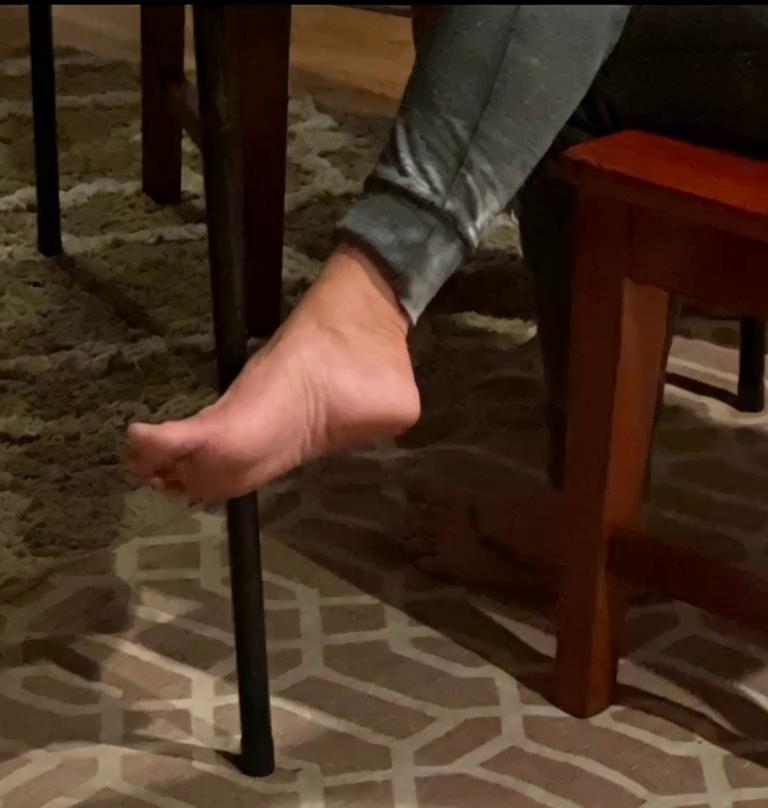 Prompt: The foot of a chimpanzee gently caresses the sole and toes of the human foot