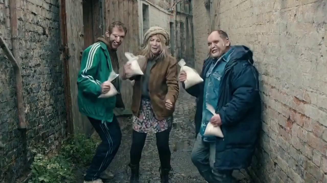 Prompt: 2 english men 1 english woman  poor, few teeth left  are in a rundown alleyway (lots of plants broken doors on the walls occasionally and mud piles)

they are dancing to slavic techno while holding clear plastic bags of flour powder and also some flour on their face 

on of them asks ''do you want a go G'' one then replies ''nah ladd thats best for baking that Fam''

the other gives his bag of flour to a really posh woman 