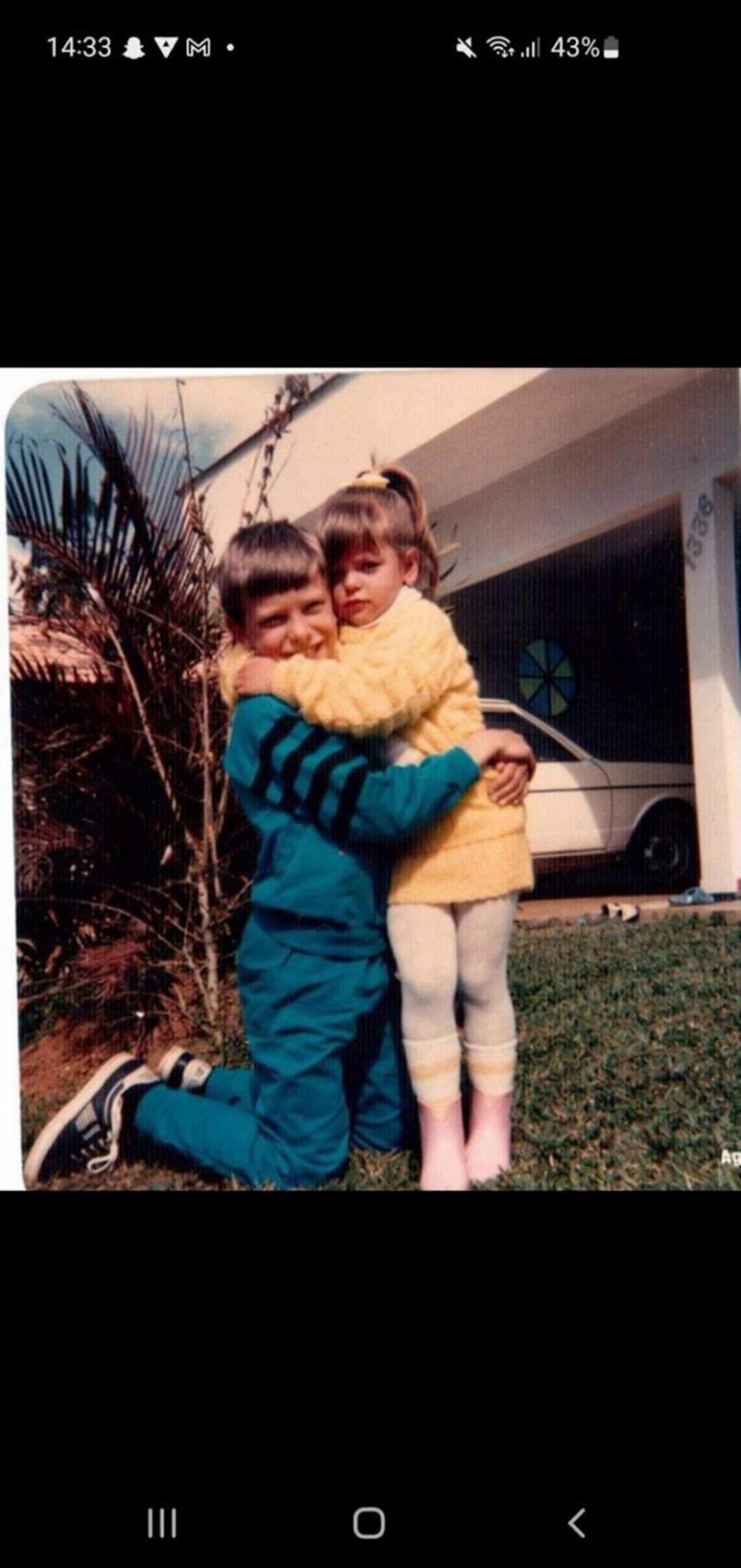 Prompt: fazer as crianças da imagem sorrir se olharem e se abraçarem denovo mantendo as caracteristicas fisicas faciais originais