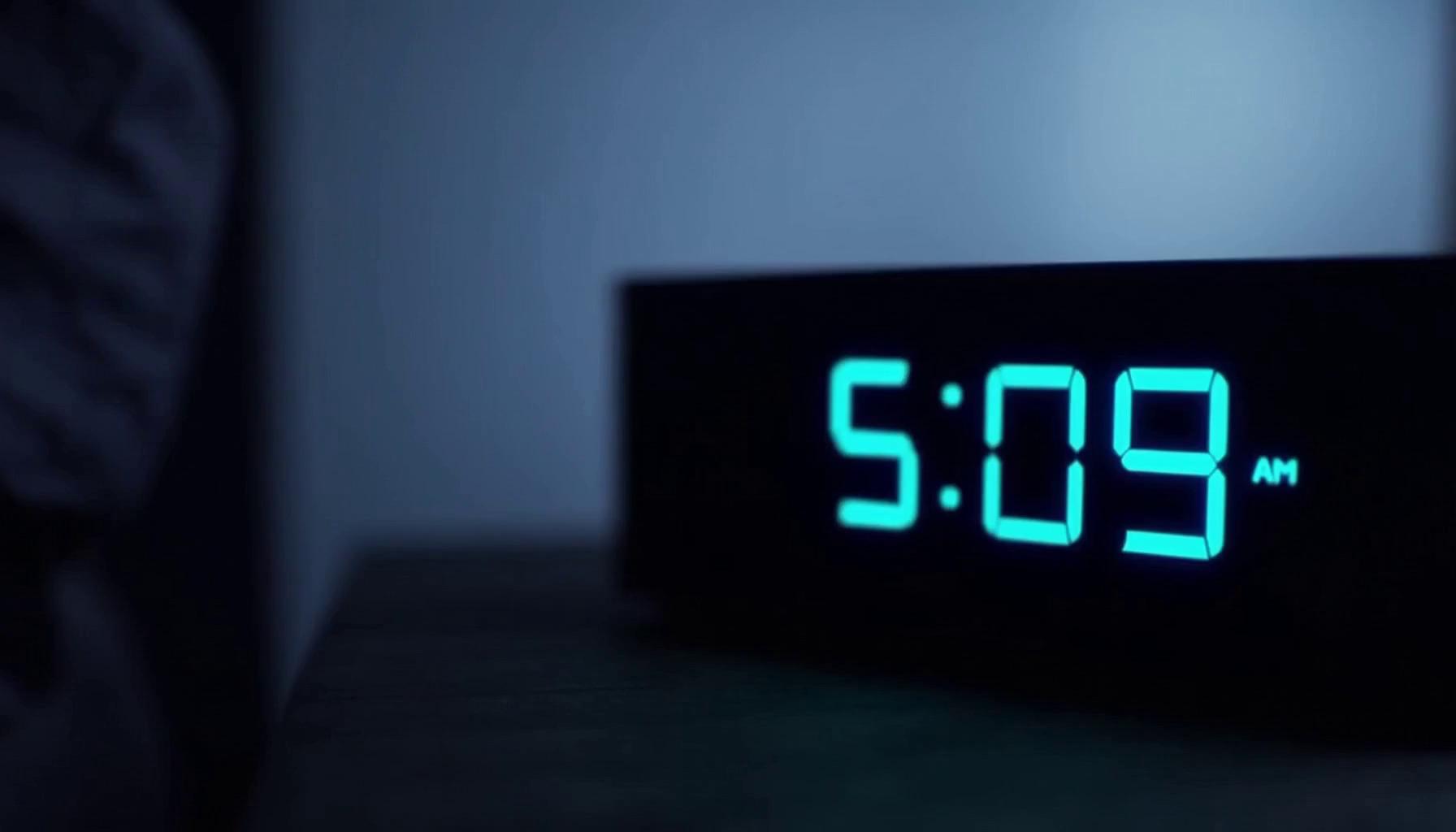 Prompt: Hyper-realistic cinematic video inspired by high-end racing game trailers. make it drive up a hill.
drives to his mansion on a hill. overlooking th esea. 

Opening shot: early morning, dim blue lighting. A digital clock reads 5:09 AM, softly glowing in a dark bedroom.

Cut to close-up: a man lying awake, eyes open, tired but alert. Cold blue tones, soft ambient light.

Quick cut: laptop screen in a dark room. A sleek modern dashboard interface shows a bold red notification:
“ACCOUNT BANNED”.

Extreme close-up: the red text reflects in his eyes. His expression hardens.

He shuts the laptop abruptly — sharp, muted thud.

Fast pacing begins.

He stands up, grabs keys from a table. Metallic click echoes.

Tracking shot: walking with purpose through a dim hallway into an underground garage.

Lights flicker on.

Reveal: a glossy black Lamborghini Huracán emerges from darkness. Cinematic reflections across the body.

Headlights snap on — bright LED beams cutting through shadows.

Interior shot: he enters, grips the wheel tightly.

Engine ignition: the V10 roars aggressively, echoing through the garage.

Hard cut to action:

High-speed night driving sequence through a neon-lit city.
Wet asphalt reflects lights, motion blur streaks across the frame.

Shots include:
- low front tracking shot close to the ground
- side angle at high speed
- interior close-up of intense focused expression
- rear shot with glowing red taillights cutting through darkness

Style: ultra photorealistic, like a AAA racing game cinematic trailer.
Lighting: moody blues, deep blacks, neon reflections.
Camera: handheld realism mixed with stabilized tracking shots.
Lens: 24mm for speed, 50mm for emotion, shallow depth of field.

Tone progression:
calm → tension → frustration → power → release.

Aspect ratio 9:16, duration 12 seconds, cinematic, ultra detailed, realistic physics, subtle film grain.