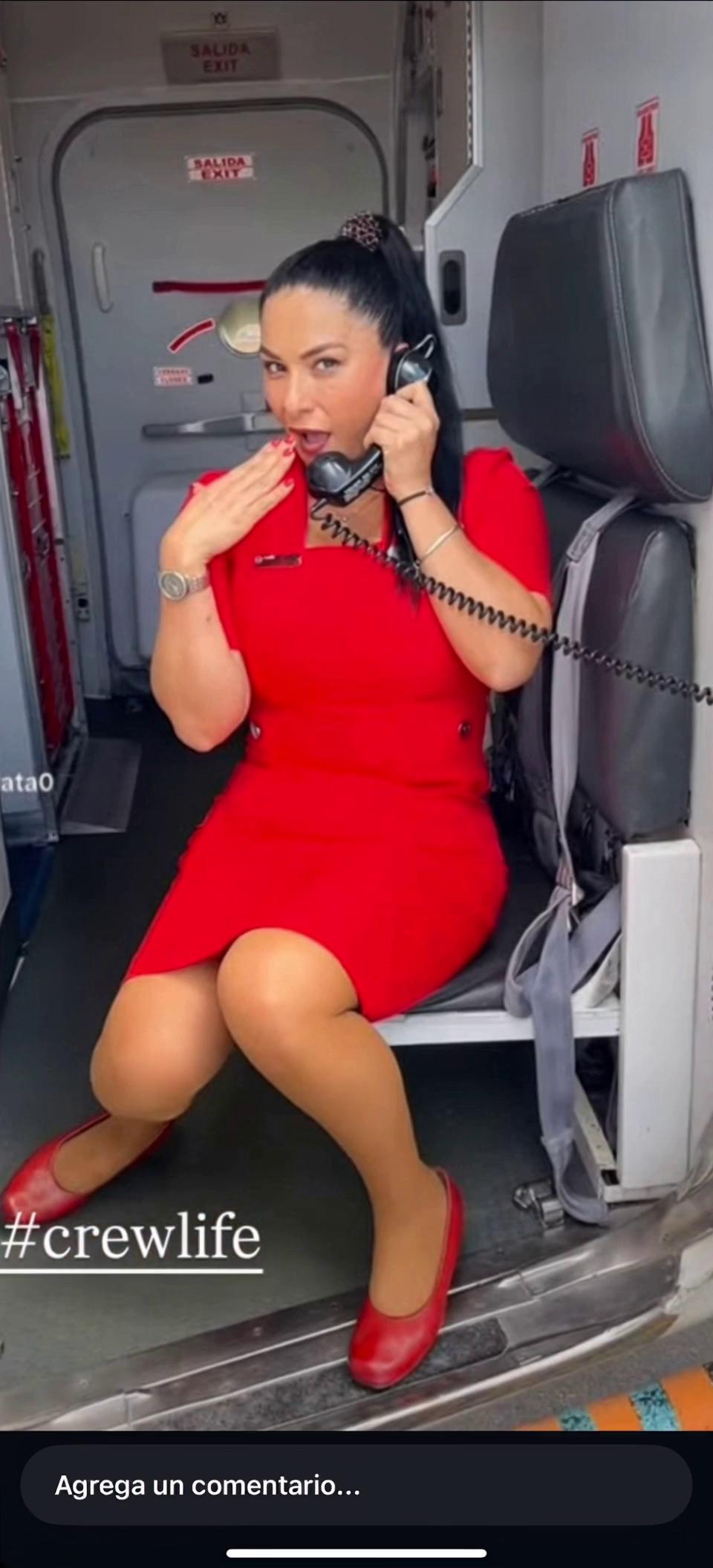 Prompt: a blond flight attendant casually speaking on the telephone moving her hans and not moving from the waist down