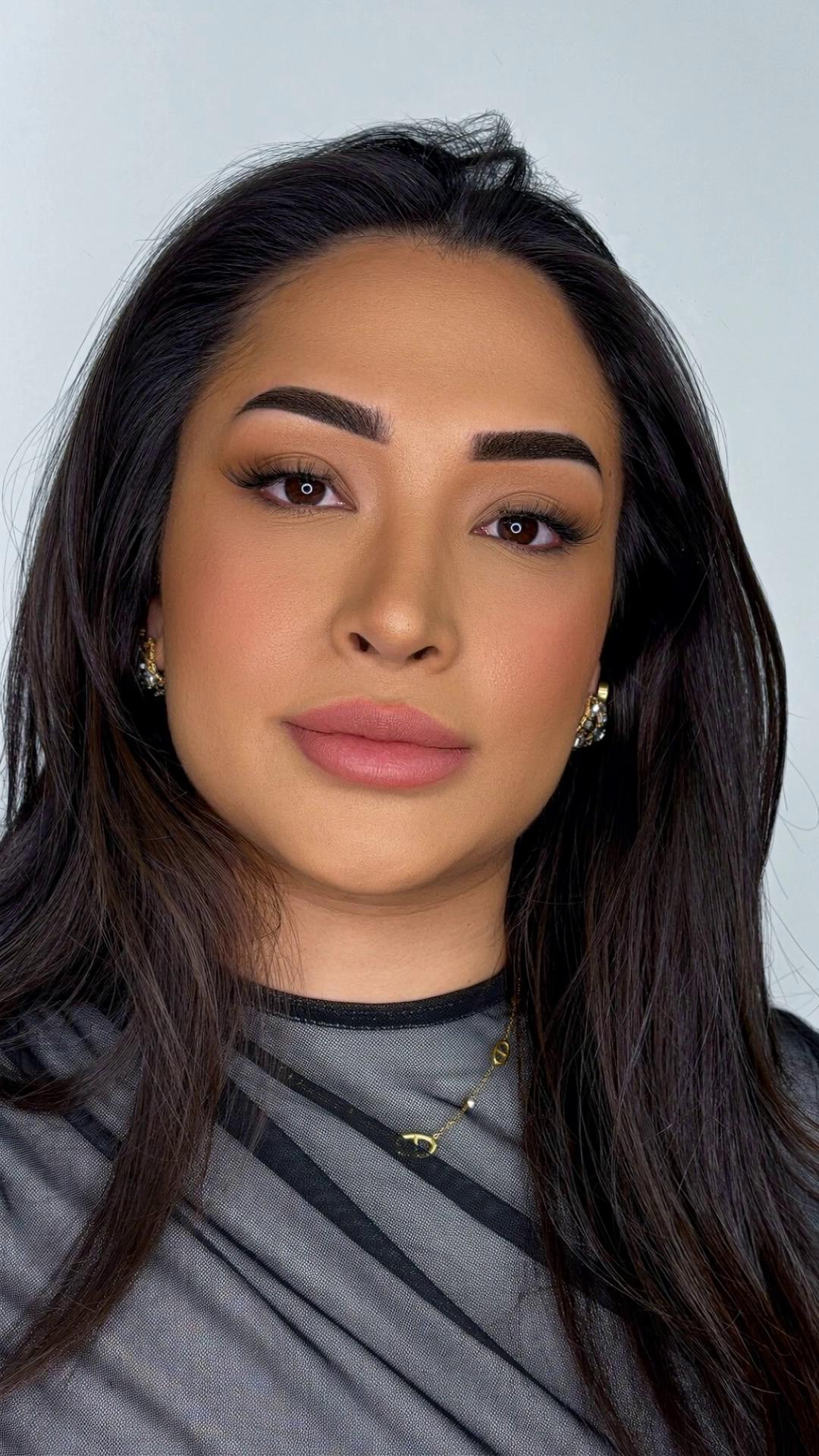 Prompt: Beauty after-reveal shot. Use this photo as base. The same woman in a clean studio, soft even light. She gently raises her eyebrows slightly and points with one index finger to the eyebrow arch (near the tail), showing the perfect brow shape. Natural smile, subtle head turn, small blink. Keep face identity, makeup, hair, jewelry and outfit unchanged. Ultra realistic skin texture, 4K, smooth motion, no camera movement.

Negative:
no face change, no identity change, no extra fingers, no hand deformation, no double eyebrows, no warping, no blur, no text, no watermark, no background change