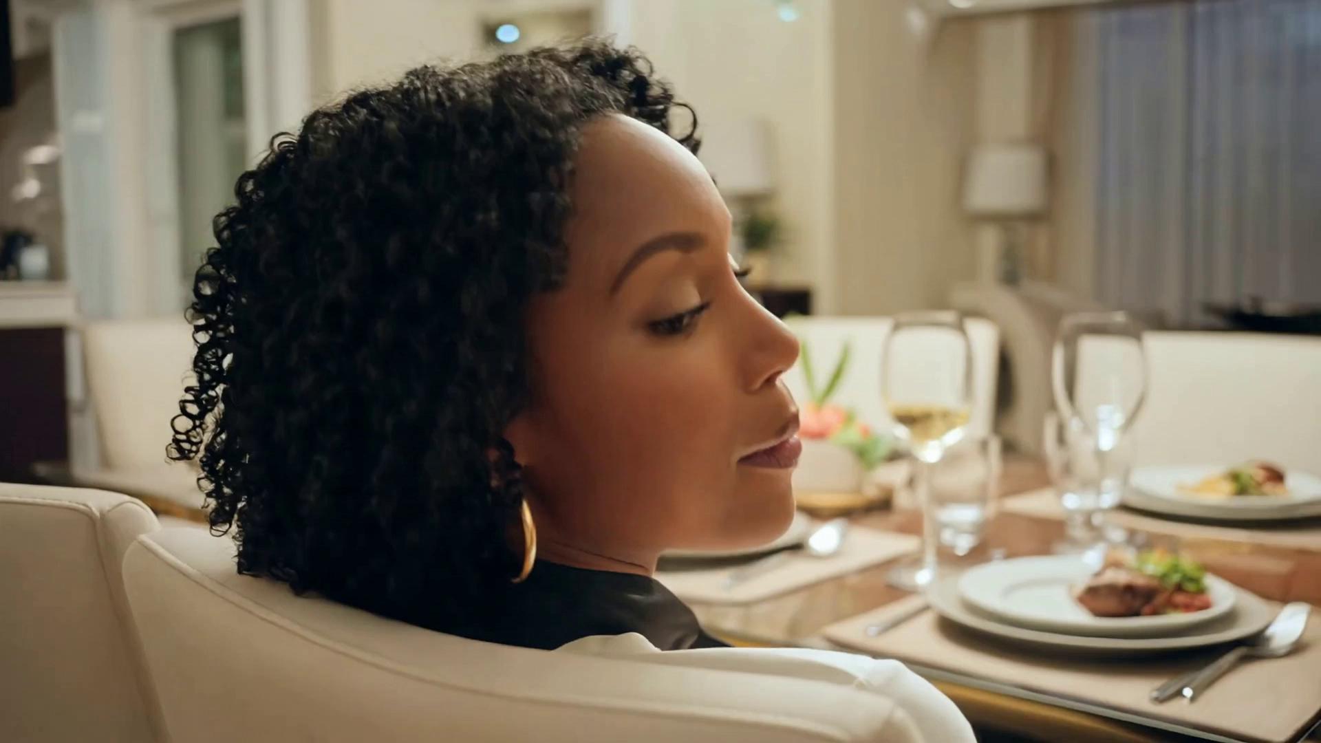 Prompt: A cinematic, slider-style camera move begins with a slow, controlled lateral glide, creating gentle parallax between the subject and the background. The camera movement is smooth, intentional, and warm, with a subtle easing at the start and end—never abrupt, never mechanical. Framing adjusts delicately as the camera settles, maintaining an elegant, composed shot.The subject remains seated and relaxed, engaging in minimal, fluid movement. Natural breathing subtly lifts and lowers the torso. A small posture adjustment occurs as weight shifts comfortably, followed by a brief pause before stillness returns. Movements are anatomically accurate and unforced, with no repetition or rhythmic looping.Micro-expressions appear organically: a soft smile forms briefly, relaxes, then returns faintly. The subject tilts their head slightly and lets out a quiet, natural laugh, then gently realigns to a neutral position. Eye focus drifts momentarily off-camera, then returns, as if reacting to an internal thought rather than external direction.Hand and arm movements are minimal and understated—fingers subtly relax and re-set once, then remain still. Timing is imperfect and human, with unconscious pauses between actions that enhance realism.The environment supports the cinematic tone with soft, atmospheric stillness—ambient light remains consistent, and background elements show only the faintest suggestion of life, responding subtly to the subject’s movement rather than drawing attention.Overall motion feels elegant, immersive, and observational—cinematic yet believable—captured as if through refined camera control during a quiet, candid moment rather than a staged performance.