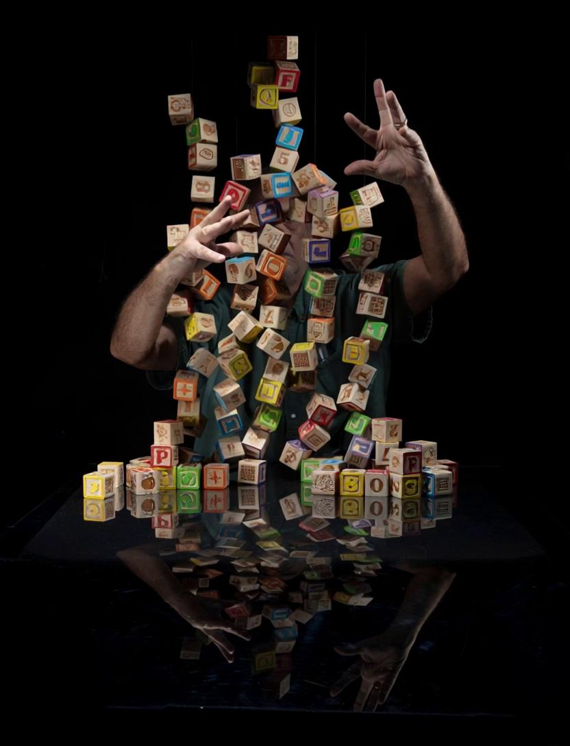 Prompt: Blocks slowing floating up into the air and a man trying to gently corral the blocks so that they don't fly away, camera panning from left to right

