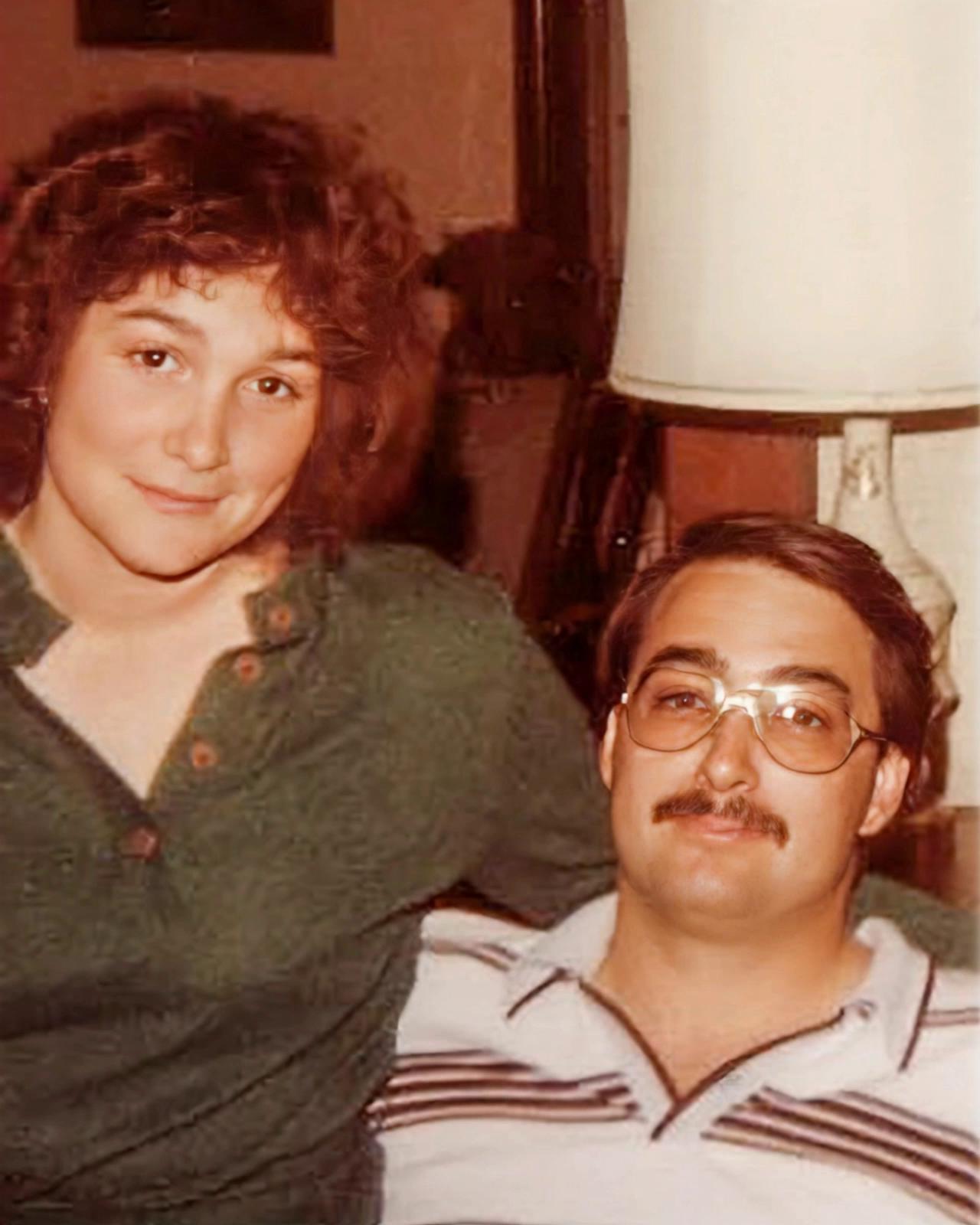 Prompt: Young man and woman looking at camera and then hugging