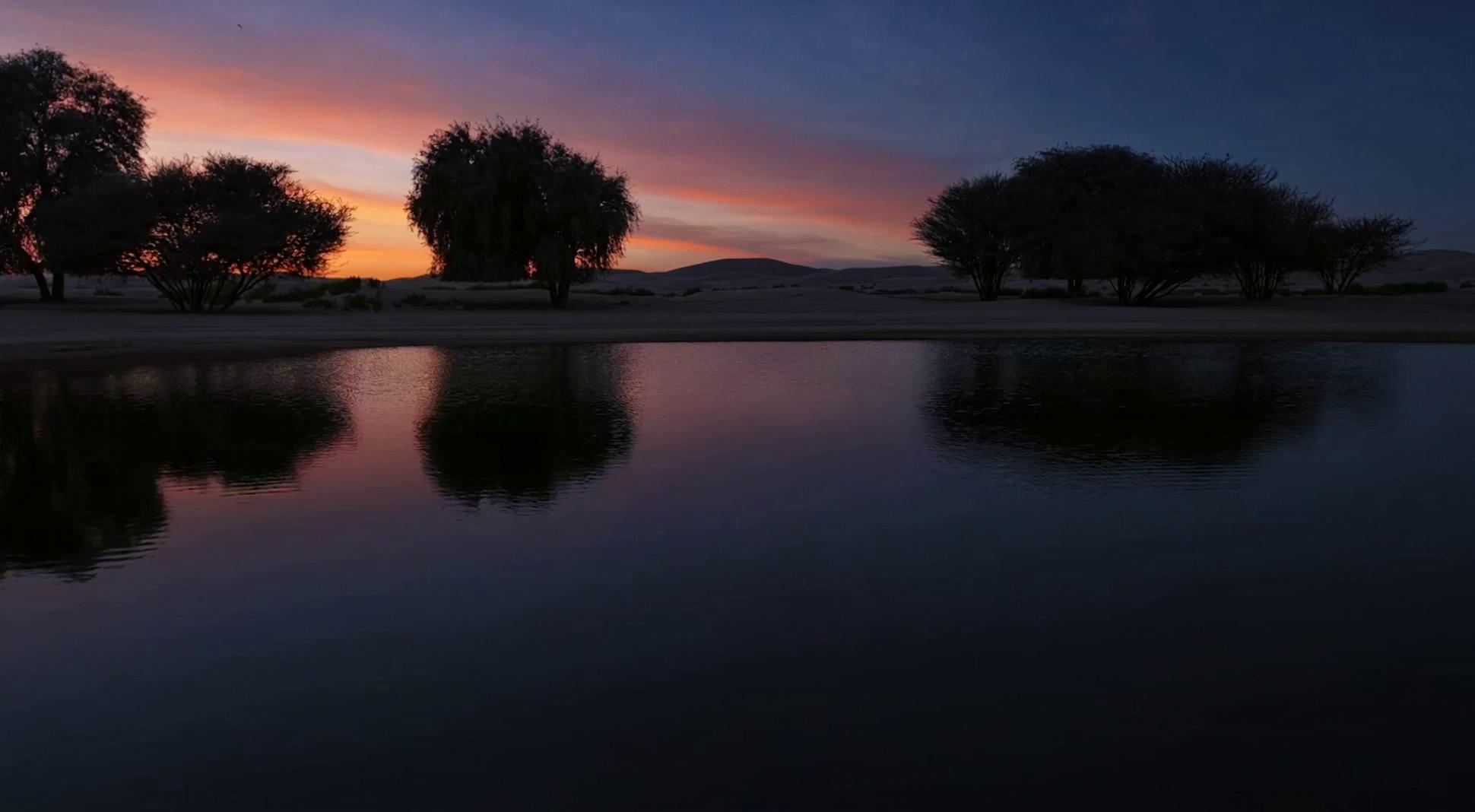 Prompt: Gradual transition from daytime to nighttime.Keep the same desert landscape, same camera angle and composition.The lighting slowly changes from bright daylight to sunset, then to night.Natural sky color transition, warm sunset tones, then deep blue night sky.No changes to terrain, sand, or objects.No new elements added.Smooth, cinematic time transition.