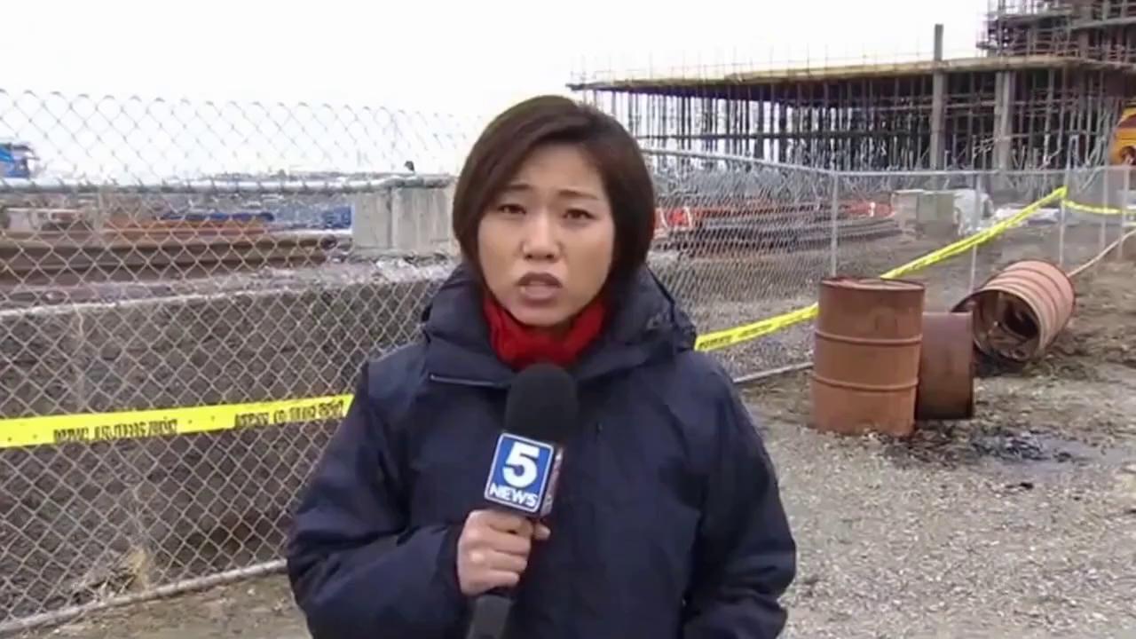 Prompt: Show a TV news story where a reporter on location at the same site says "Yes, Jackie, leaking drums have been discovered at the McKinstry Enterprises project.  Looks bad for Bobby."