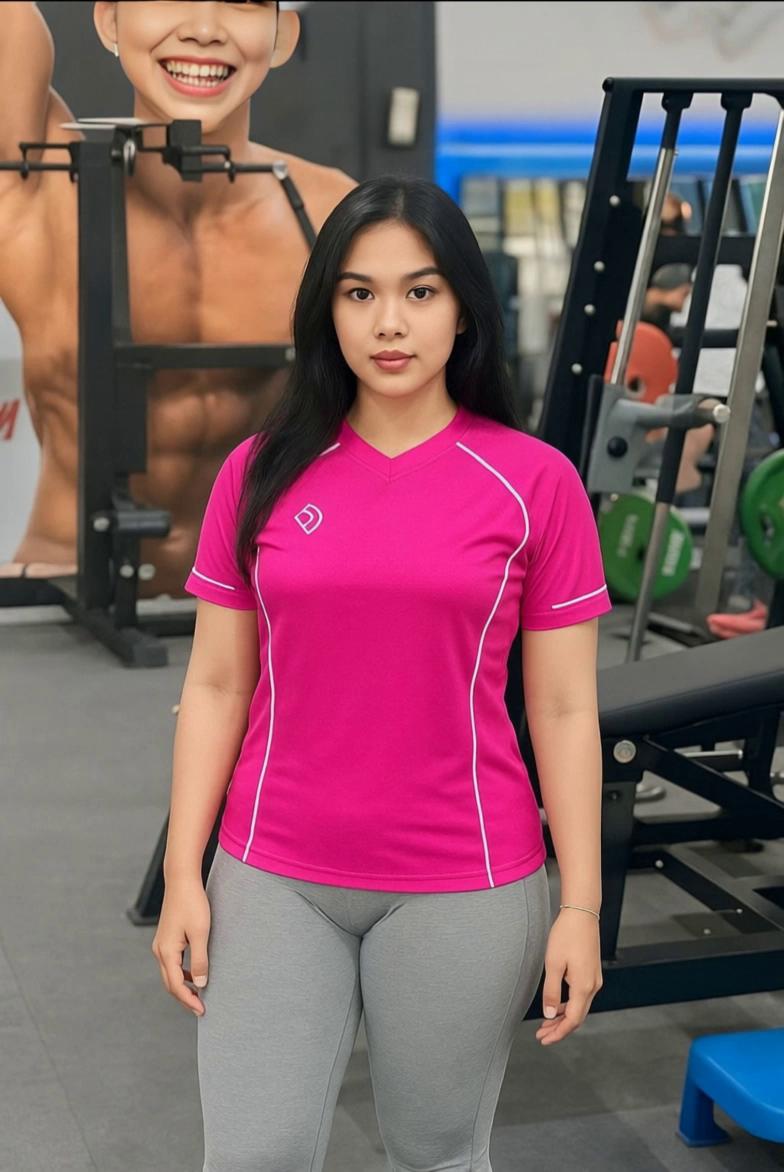 Prompt: A female model stands in a gym under natural lighting, slowly caressing the pink sports T-shirt she’s wearing as if reviewing its fabric quality and comfort. Her movement is gentle and elegant, focusing on the texture and folds of the shirt. The camera stays still in a 9:16 vertical format, highlighting her upper body and hands as they softly touch the shirt with a calm and professional expression.