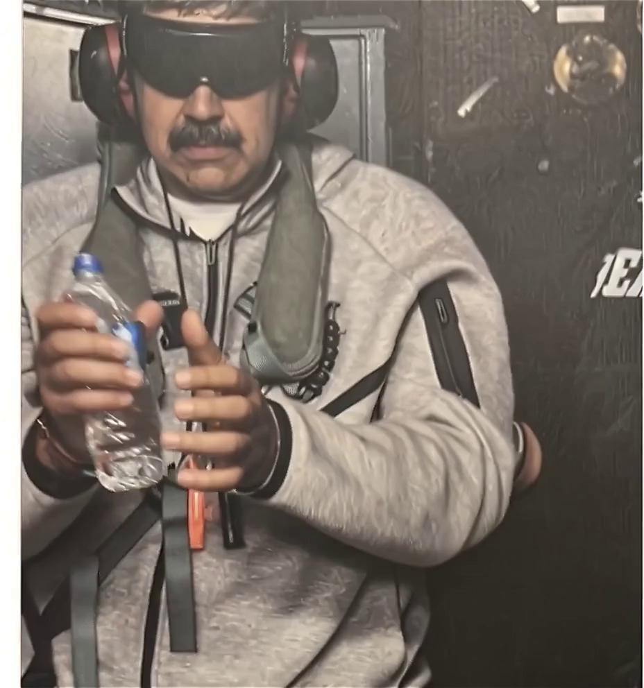 Prompt: have the man in the photo stand up wearing the same nike tech fleece outfit from top to bottom and start dancing to cumbia music and then have him while dancing move down the interior of the battlship he is on with people dancin with him