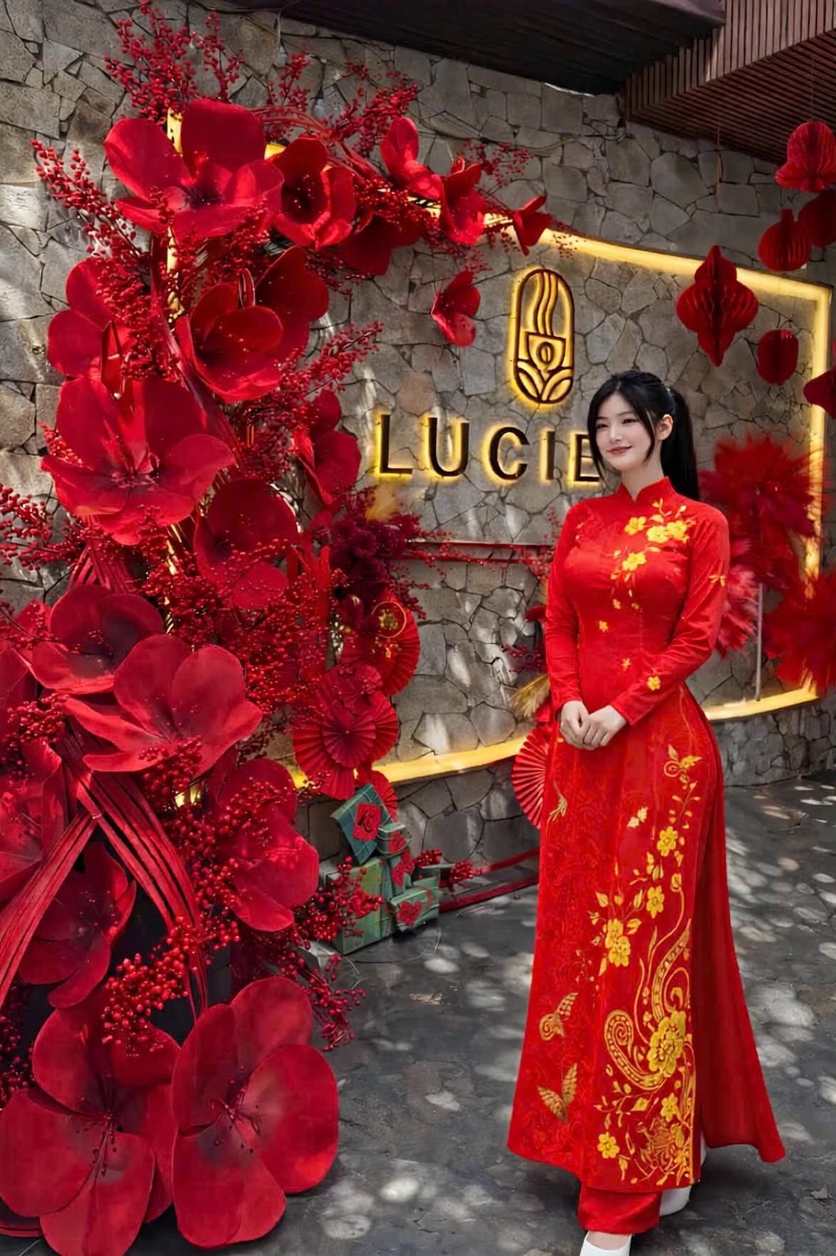 Prompt: A young Vietnamese woman wearing a traditional red embroidered áo dài, same face, same body shape, same hairstyle as the reference image.

She is posing for a video with slow, graceful movements.

Movement details:
– She starts standing straight, then gently shifts her weight to one leg, creating a natural S-shaped posture.
– Her upper body slowly turns slightly to the left, shoulders relaxed, creating a soft and elegant angle.
– Her right hand slowly lifts and lightly holds the flowing fabric of the áo dài near her thigh, letting the fabric move naturally.
– Her left hand rests gently near her waist, fingers relaxed and slightly curved.
– She subtly tilts her head a few degrees, maintaining eye contact slightly off-camera, not directly staring at the lens.
– Her expression is calm, confident, and gentle, with a soft smile.
– The movement feels continuous and smooth, as if captured mid-motion during a cinematic video shoot.

Style & quality:
Cinematic video pose, elegant and feminine, realistic motion feeling, natural body language, photorealistic, high detail, soft lighting, shallow depth of field, professional fashion video aesthetic.

Constraints:
Do not change face, body proportions, hairstyle, or outfit design. Only adjust pose and movement. No distortion, no exaggeration.