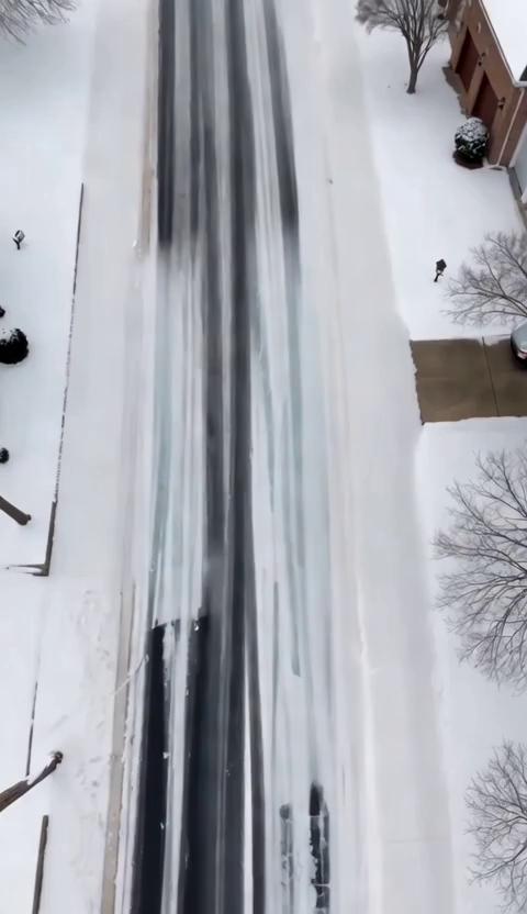 Prompt: Create a video showing a snowy road in North Carolina and a car sliding down a suburban road on sheer ice until it bumps into the curb 