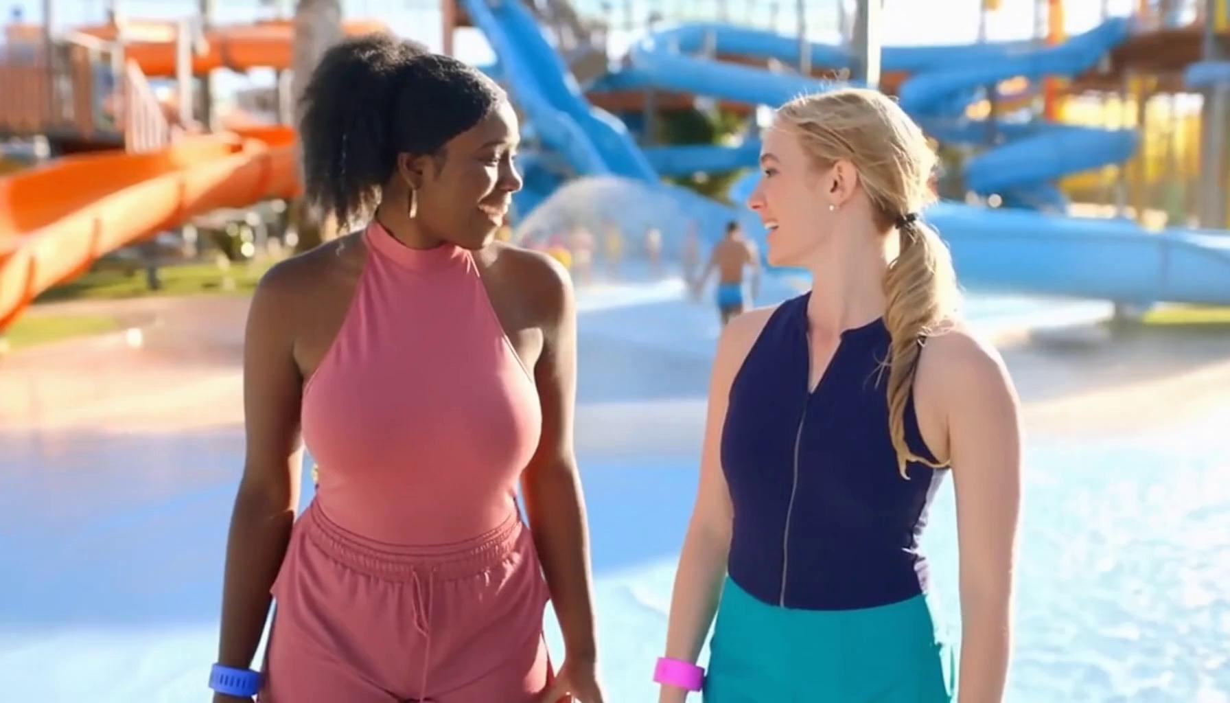 Prompt: two cheerful and excited beautiful women, one African American, the other blonde, in a water park, discussing if they should go to the bar