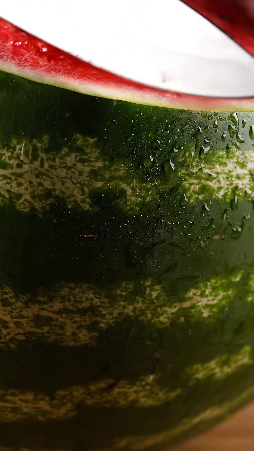 Prompt: A hyper-realistic, ultra-satisfying close-up video of an extremely ripe, deep-crimson watermelon overflowing with juice, shown entirely in real-time. A razor-sharp stainless steel knife presses cleanly into the watermelon, and juice immediately pours out in thick, glossy streams, running rapidly down the flesh and rind.

Each continuous slice causes fresh bursts of juice to ooze and drip without slowing down—fast, natural flow that looks heavy and saturated. As multiple slices are made in quick succession, the watermelon separates smoothly, with juice constantly spilling, pooling, and dripping. The interior flesh appears dense, crisp, and visibly soaked, with shiny black seeds coated in juice.

Cutting follows a tight, satisfying rhythm—press → slice → separate—without pauses or slow motion. Soft natural lighting, neutral background, extreme macro clarity, and shallow depth of field emphasize wet texture, shine, and movement. Subtle ASMR audio: clean knife cuts, wet squelch, continuous dripping.

Shot in 4K, 60fps, cinematic macro lens. Fast, refreshing, extremely juicy, visually addictive, and perfectly suited for Oddly Satisfying / TikTok audiences.