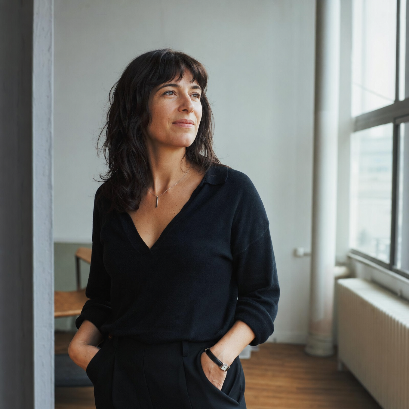 Calm, self-assured professional standing at ease in a bright minimal loft space