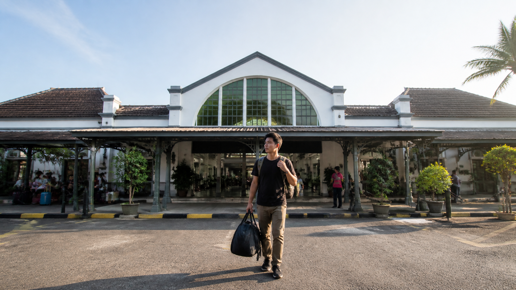 A cinematic shot of Purwokerto train station's modern yet classic architecture, with a traveler carr