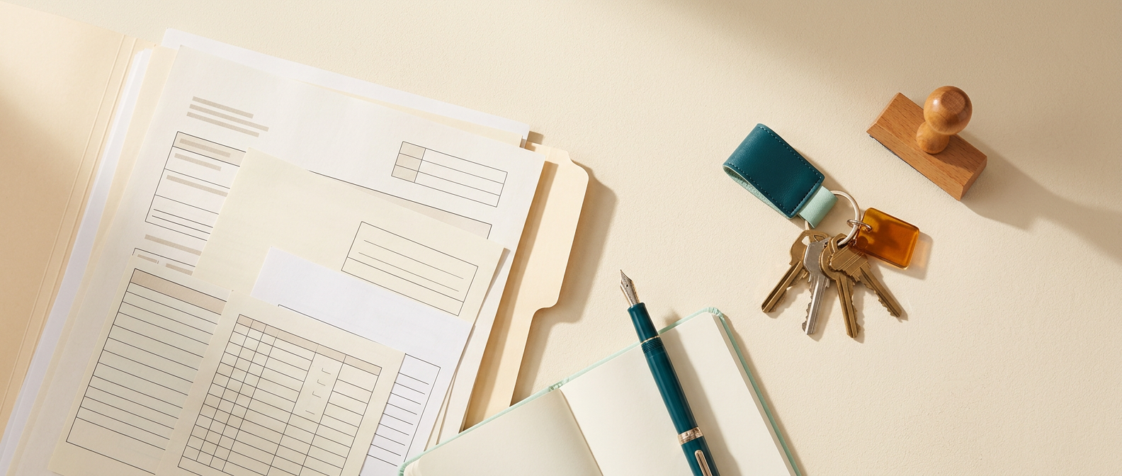Business registration papers, a pen and a set of house keys on a desk