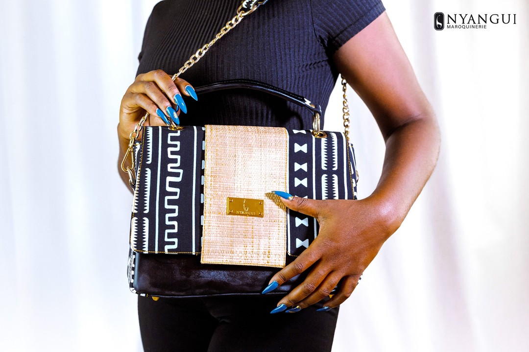 Sac Nyangui Maroquinerie porté, associant noir, matière naturelle et motifs graphiques