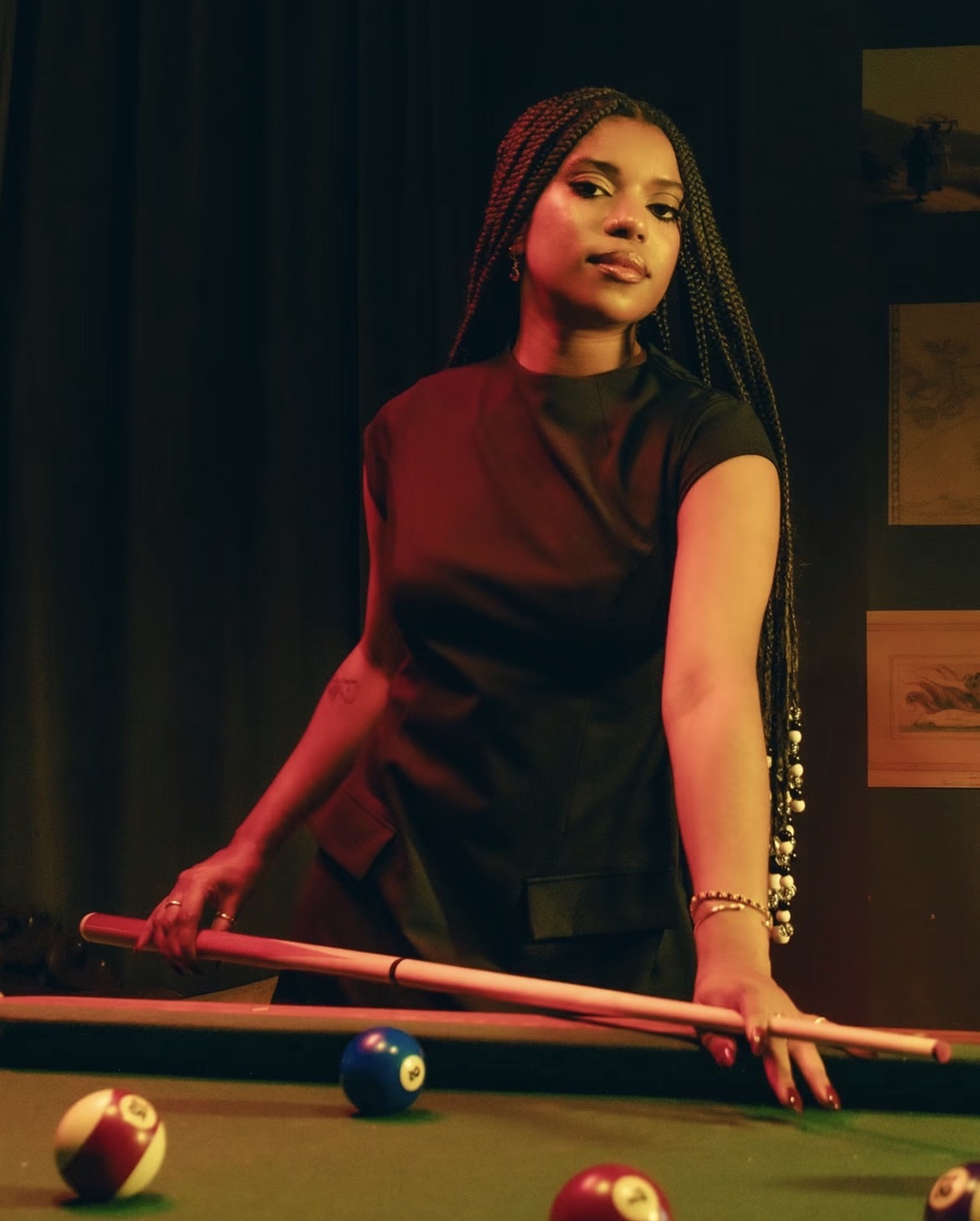 Dani Offline standing at a pool table under red and amber light
