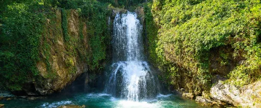 Prompt: (Kobuleti Waterfall), majestic cascading water, vibrant lush greenery, rocky cliffs, serene atmosphere, panoramic views, (4K resolution), crystal-clear water, soft sunlight filtering through the trees, tranquil setting, ideal for relaxation, picturesque landscape, nature's beauty, inviting scene, perfect for tourism, explore the wonders of western Georgia.