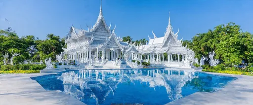 Prompt: Wat Rong Khun, Chiang Rai, Northern Thailand, Thailand

Wat Rong Khun, known as the White Temple, is located 13 km from the center of Chiang Rai. This modern Buddhist temple was designed and built by artist Chalemchai Kositpipat and opened to visitors in 1997. The temple impresses with its unique architecture, white color and many mirror elements symbolizing purity and spiritual enlightenment.

Inside the temple, you can see impressive paintings and sculptures that reflect Buddhist teachings and modern culture. The best time to visit is in the morning or evening, when the light highlights the beauty of the temple. You can get to Wat Rong Khun by taxi or bus from Chiang Rai.