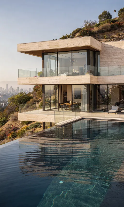 Prompt: Ultra-realistic cinematic architectural photography of ONE single modern luxury hillside residence located in Los Angeles, California, inspired by Selling Sunset.

This is the SAME residence across all images.
Identical architecture, materials, proportions, and setting in every image.

Single-frame composition only.
One space per image.
No collage.
No split frames.
No multiple scenes in one image.

Architecture:
Sculptural modern hillside home with clean minimal forms.
Light travertine stone, warm concrete, expansive floor-to-ceiling glass.
Strong horizontal lines, open volumes, large terraces carved into the hillside.
Bright, refined, architectural luxury.
No dark moody styling.
No light oak interiors.

Lighting:
Soft early morning Los Angeles daylight.
Natural light fills interiors and exteriors.
Gentle shadows.
Physically correct reflections.
Fresh, aspirational atmosphere.

Style & mood:
Selling Sunset–level dream home.
High-end, refined, expensive, modern.
A place people immediately want to live.
Calm, confident luxury.

Technical:
Vertical 9:16.
Ultra-sharp, ultra-realistic.
Stable perspective.
No people.
No text.
No logos.
No watermarks.
[MASTER PROMPT]

Scene:
Infinity-edge swimming pool integrated into the hillside.
Still water with subtle ripples.
Glass balustrades.
The same residence visible behind the pool.

Camera:
Eye-level architectural shot.
Pool dominates foreground.
