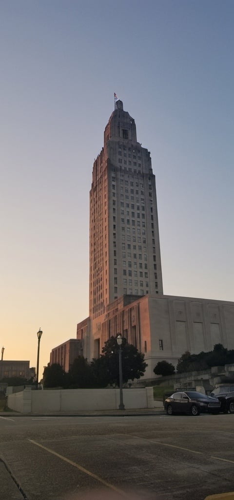 Prompt: a tall building  and a street light in front of it, Dave Arredondo, regionalism, sunset lighting,