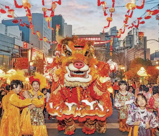 Prompt: The festive Chinese New Year. Lion dancing on the street, happy smiles on people's faces. The background of the picture is the building of a fashionable city. The overall red tone, the face of the characters is high-definition. Soft tones.