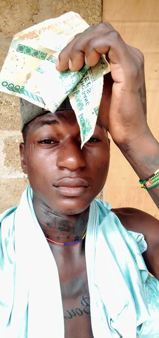 Prompt: ALi Boubacar has tattoos all over his body and he's holding money again