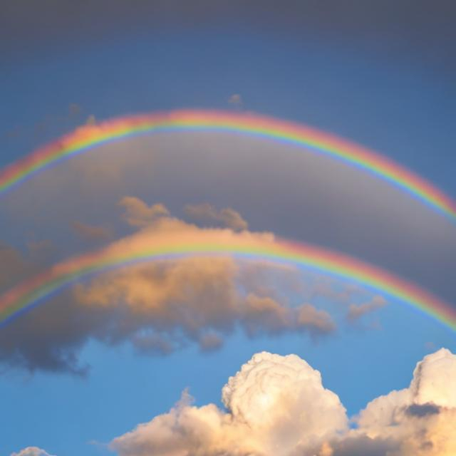 Prompt: Moon and sun rainbow clouds in background