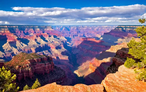 Prompt: photorealistic, (breathtaking view), vibrant color scheme, vast and awe-inspiring Grand Canyon, dramatic lighting casting shadows on layers of rock, intricate details in canyon formations, expansive sky, rich earthy tones with highlights, tranquil ambiance, serene atmosphere, ultra-detailed, high-definition landscape, emphasizing depth and scale, capturing the majesty of nature.