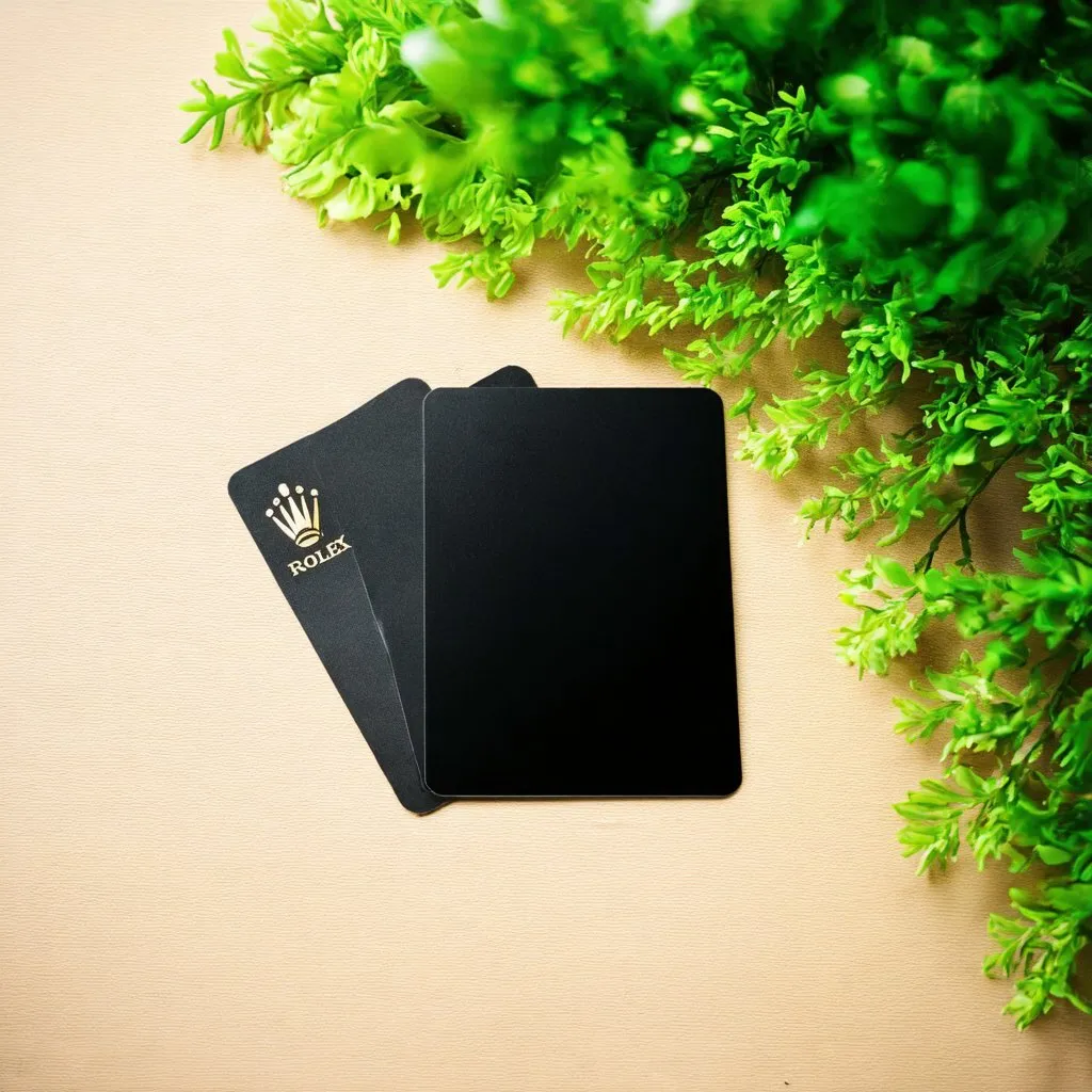 Prompt: a blank black colour nfc card with the rolex logo on it . Have greenery as the background

