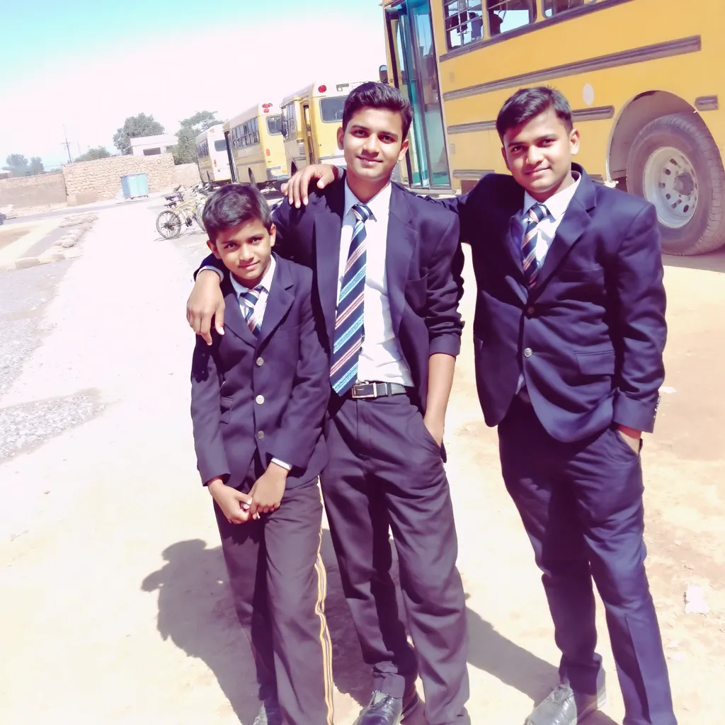 Prompt: Three young boys stand confidently in a dusty outdoor setting, wearing smart school uniforms that consist of dark blazers, white shirts, and striped ties. They are surrounded by a backdrop of yellow school buses parked nearby, suggesting a school environment, likely during the day under clear blue skies. The boys strike a casual pose, with expressions that convey camaraderie and youthful enthusiasm, while the remnants of a gravel path and a few bicycles in the distance hint at an active school scene. The overall mood reflects a sense of belonging and teamwork, encapsulated within a typical school day atmosphere.